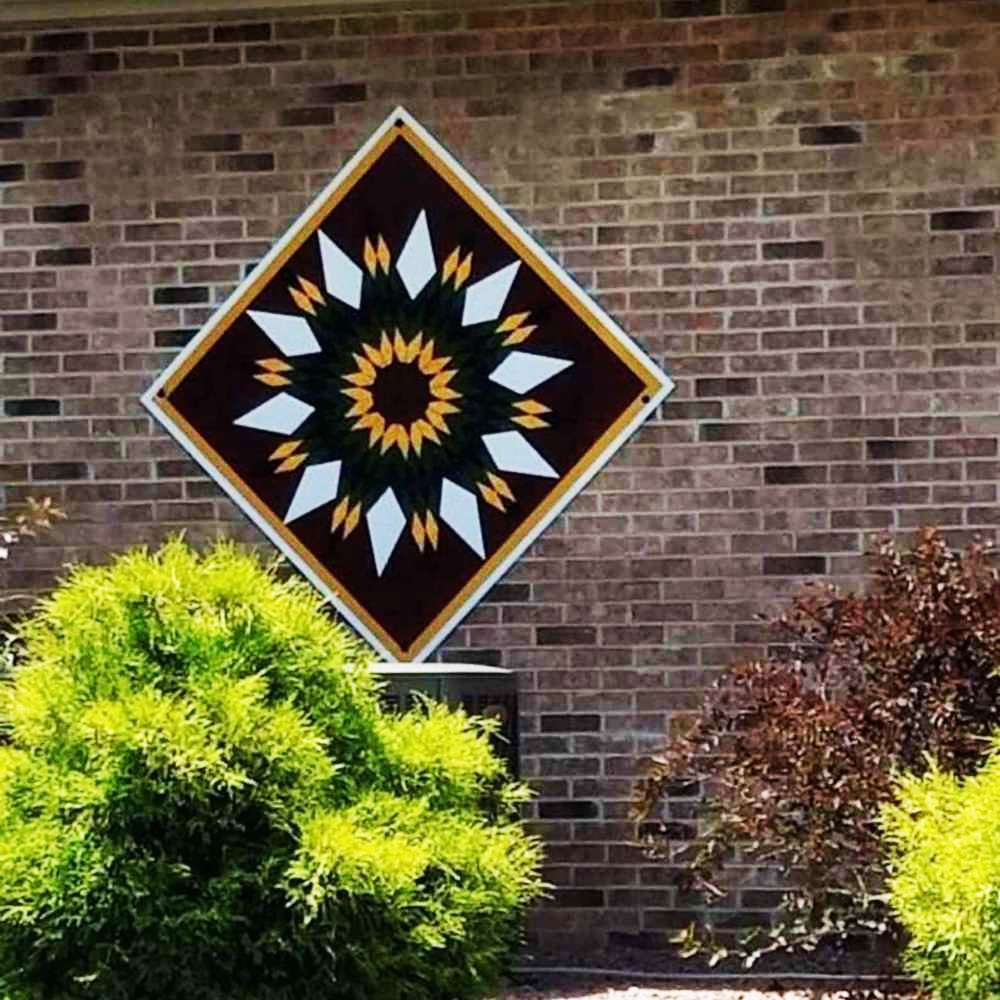 a sunflower barn quilt hanging on the  brick wall