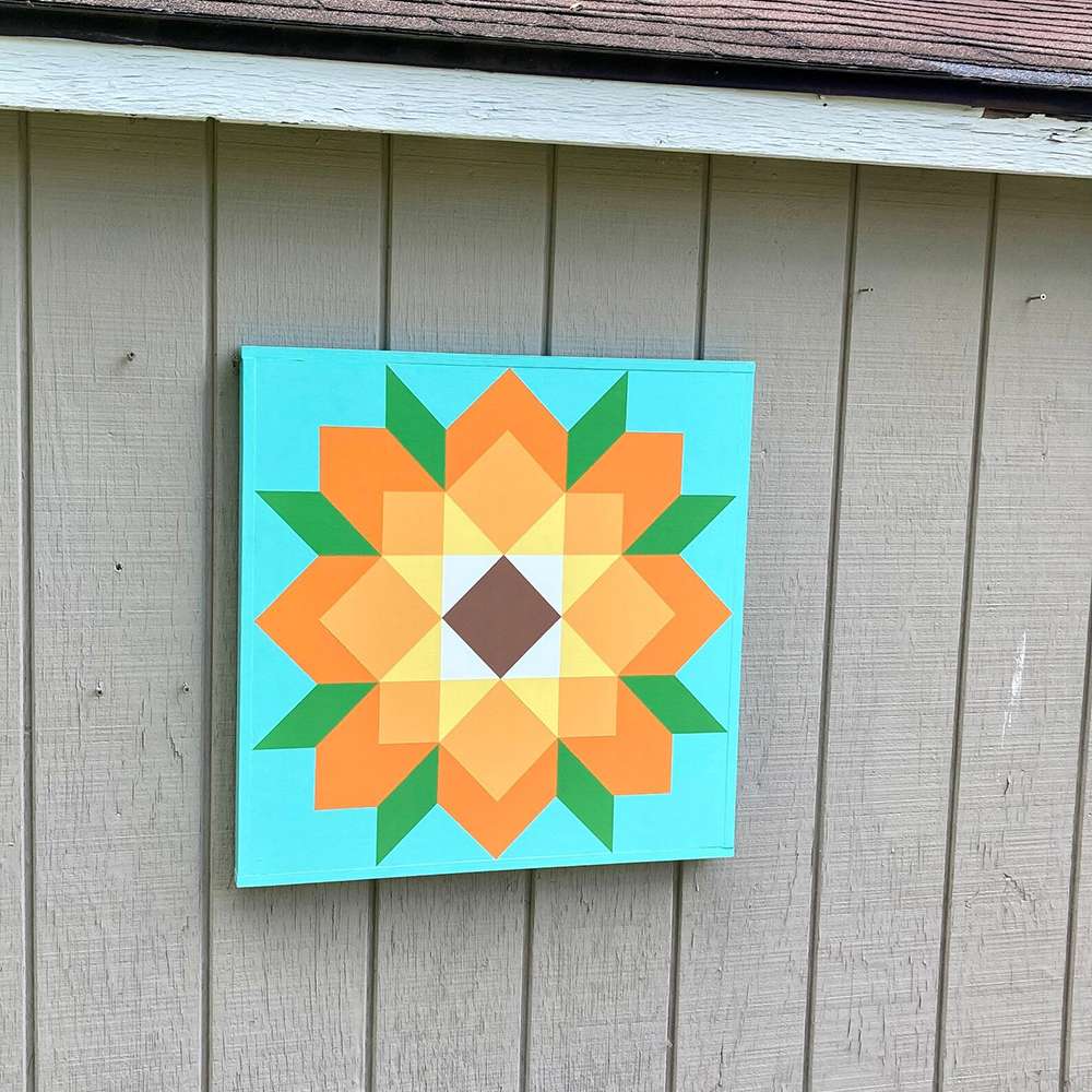a sunflower barn quilt hanging on the wall