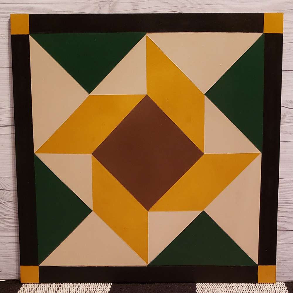 a sunflower barn quilt hanging on the wooden wall