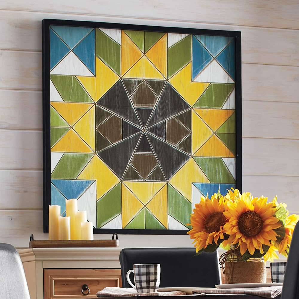 a sunflower barn quilt hanging on the wall above the wooden cabinet