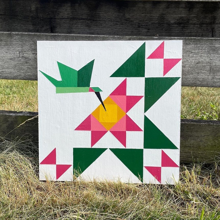 the barn quilt with three distinct tulips and a flying bird pattern