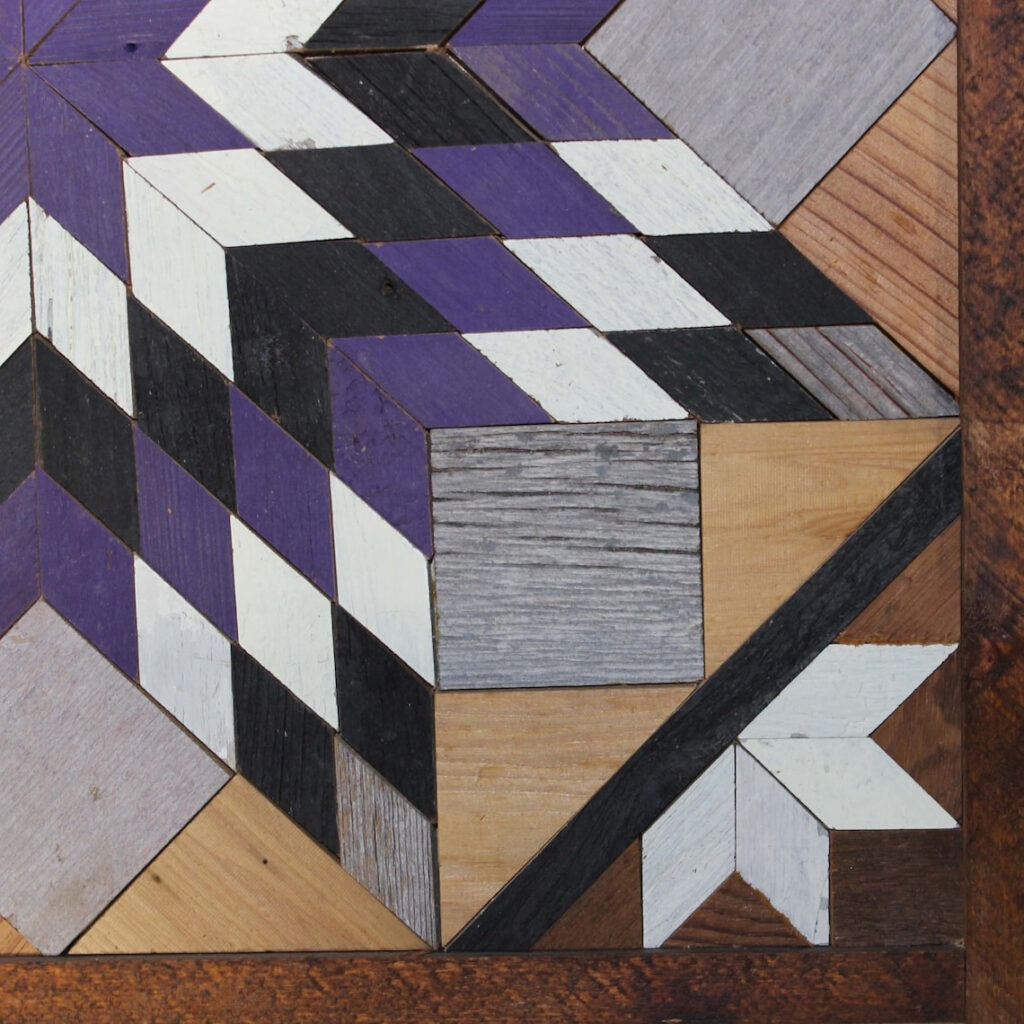 A part of the square barn quilt with purple and black and white giant star pattern.