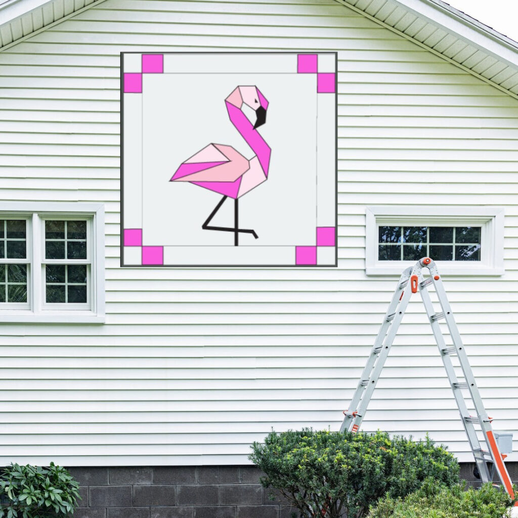 the square barn quilt with Flamingo pattern hanging on the white wall