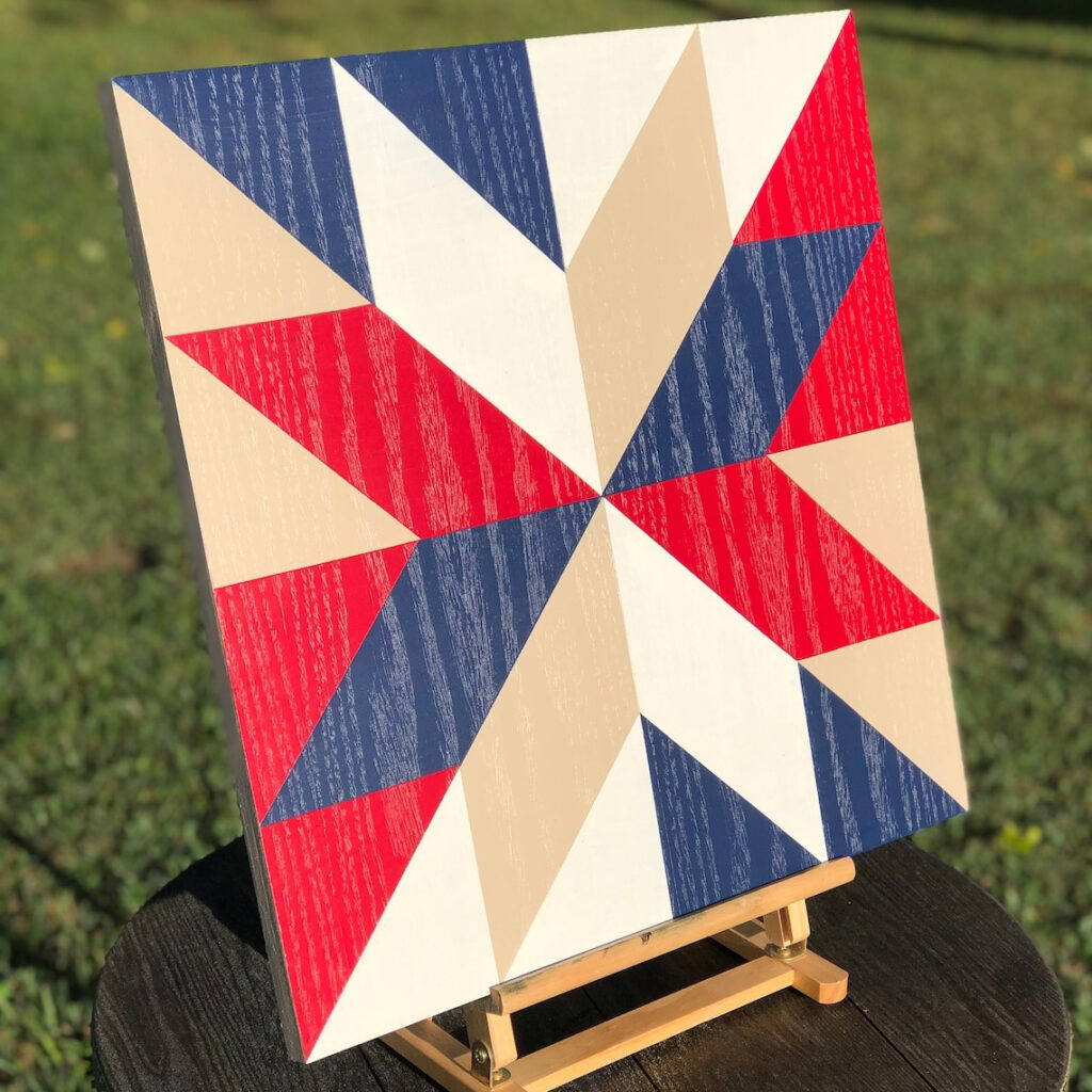 the square barn quilt with patriotic star pattern placed on the wood rack