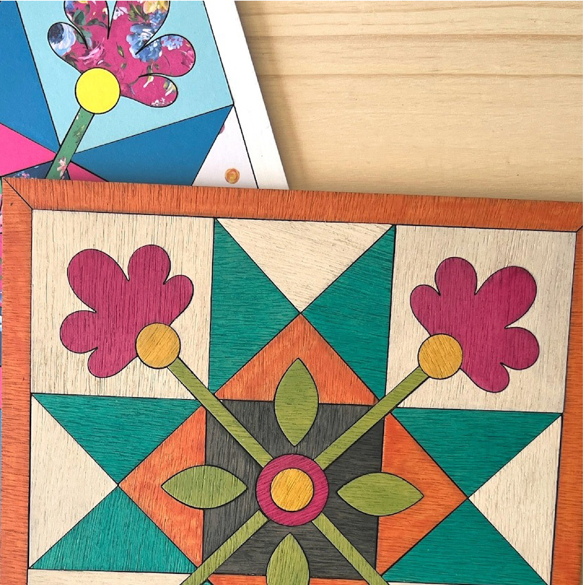 A part of a square barn quilt with stars and flowers patterns