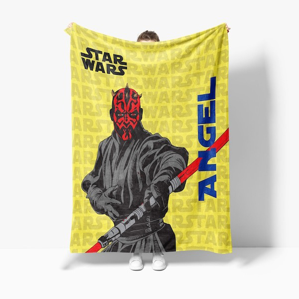 Holding up a customized Star Wars-themed quilt
